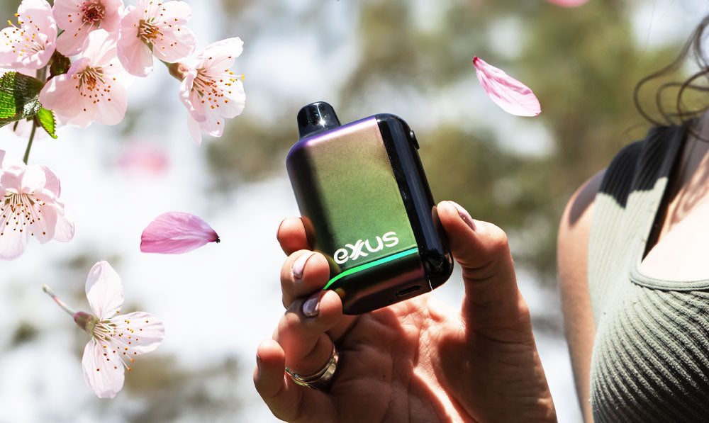 Person holding a Exxus Snap DLX with cherry blossoms in the background